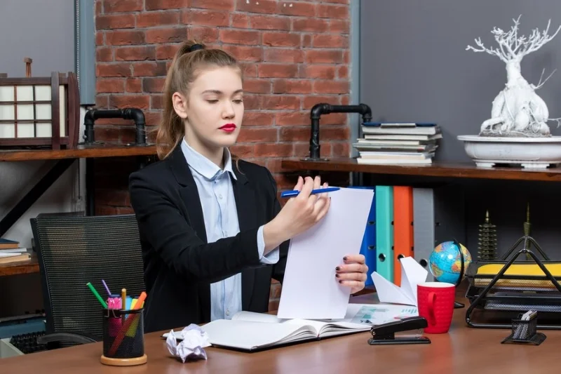 Nhân viên xem hồ sơ tại bàn làm việc có quả địa cầu