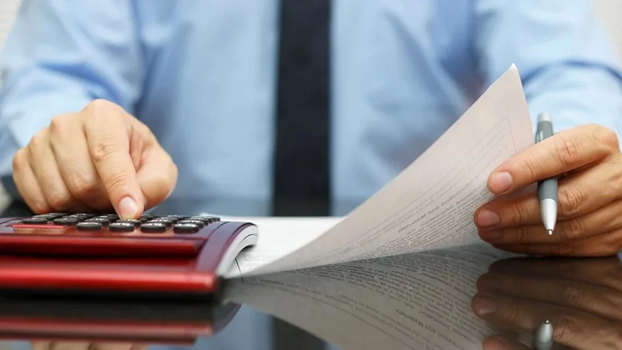 Người sử dụng máy tính cầm tay khi kiểm tra chứng từ.