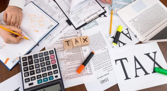Bàn làm việc với máy tính và hồ sơ thuế