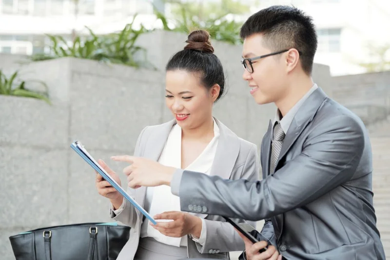 Hai người trao đổi bên máy tính bảng