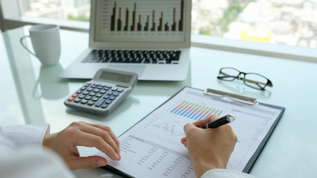Bàn làm việc với máy tính và hồ sơ kế toán cuối năm