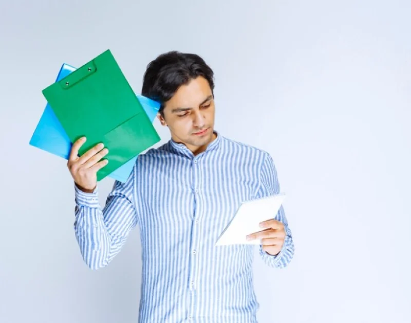 Người đàn ông xem giấy tờ và cầm các bìa hồ sơ